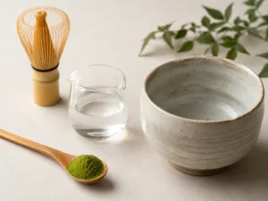 A measured teaspoon of matcha powder beside a small amount of water, showing the correct matcha ratio.